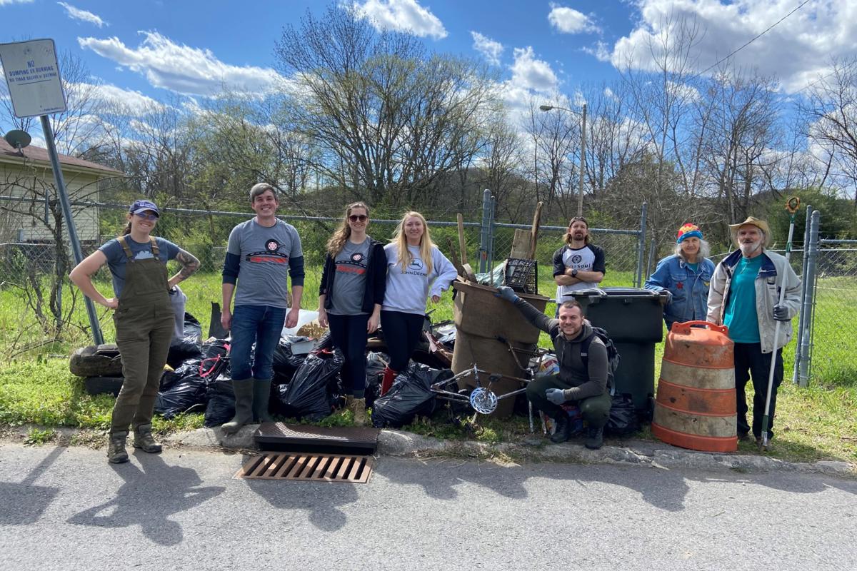 a group of people standing next to trash bags
