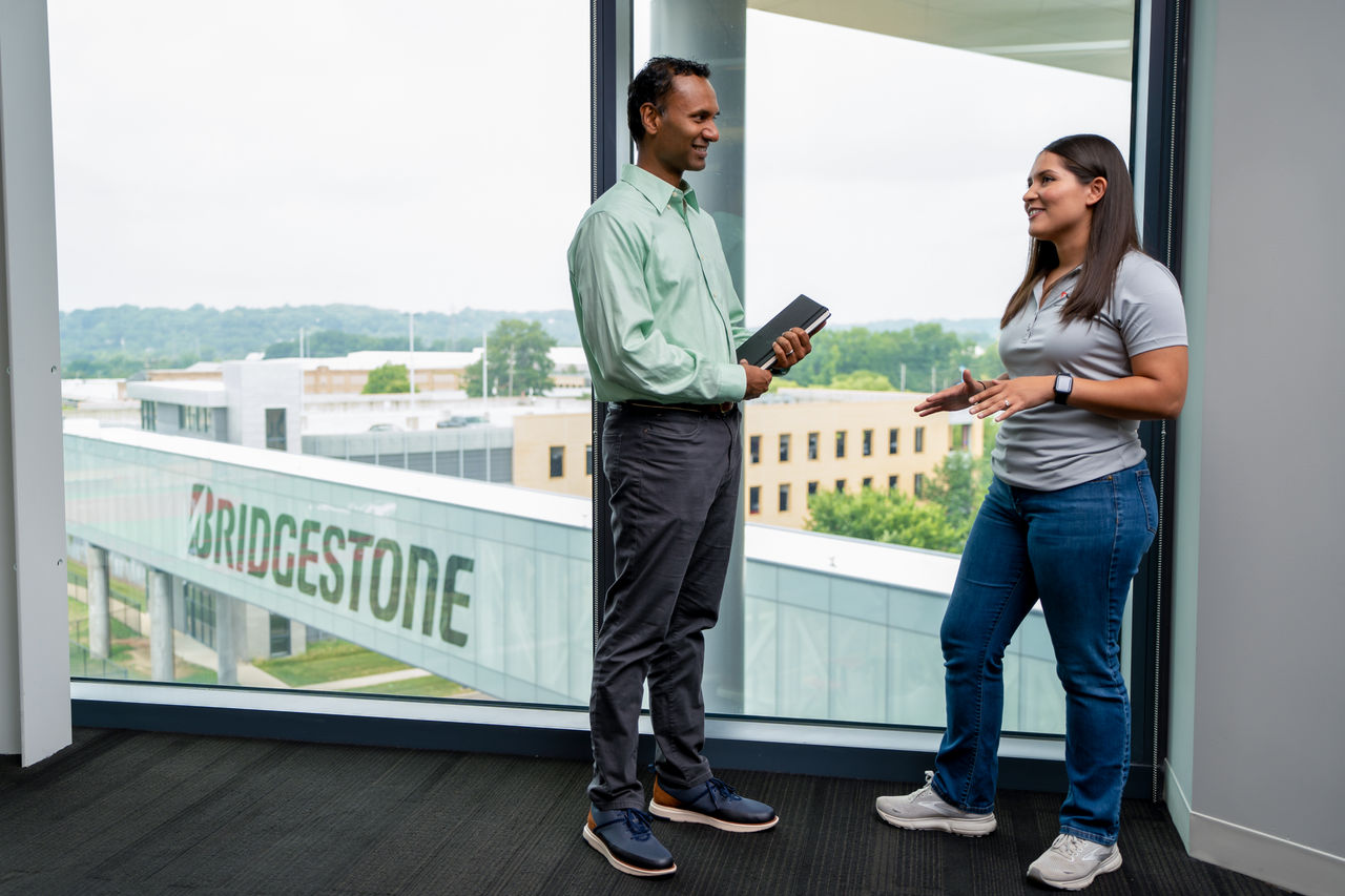 a man and woman standing in front of a window