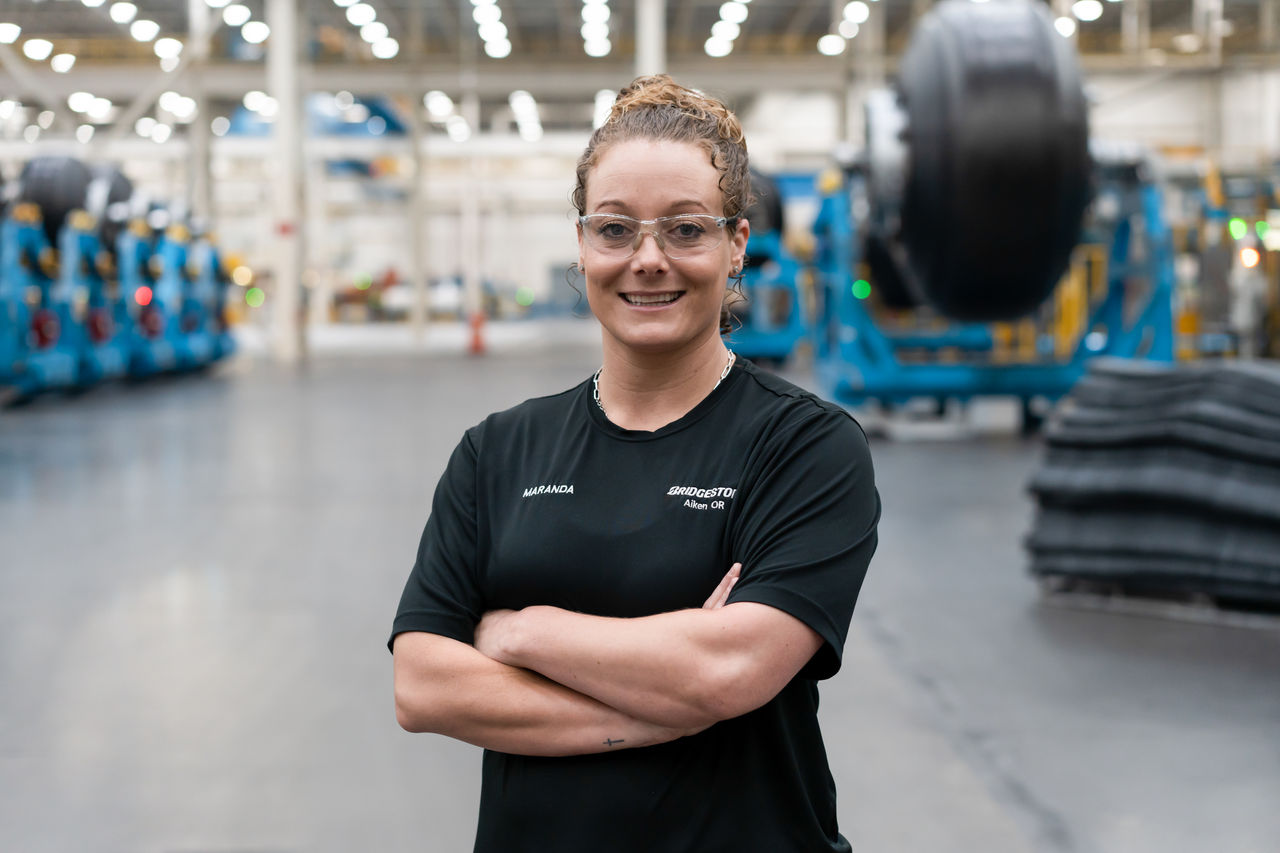 a woman wearing glasses and standing in a warehouse