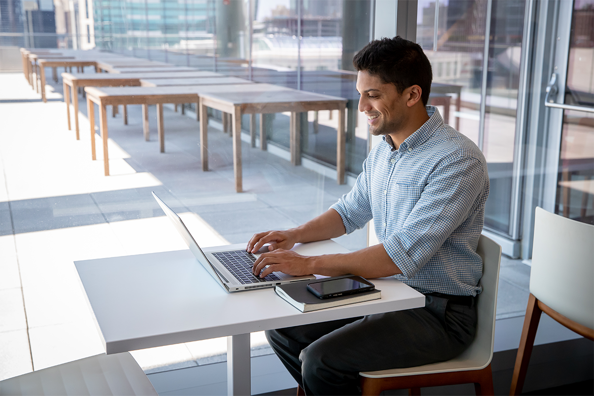 a man sitting at a table using a laptop