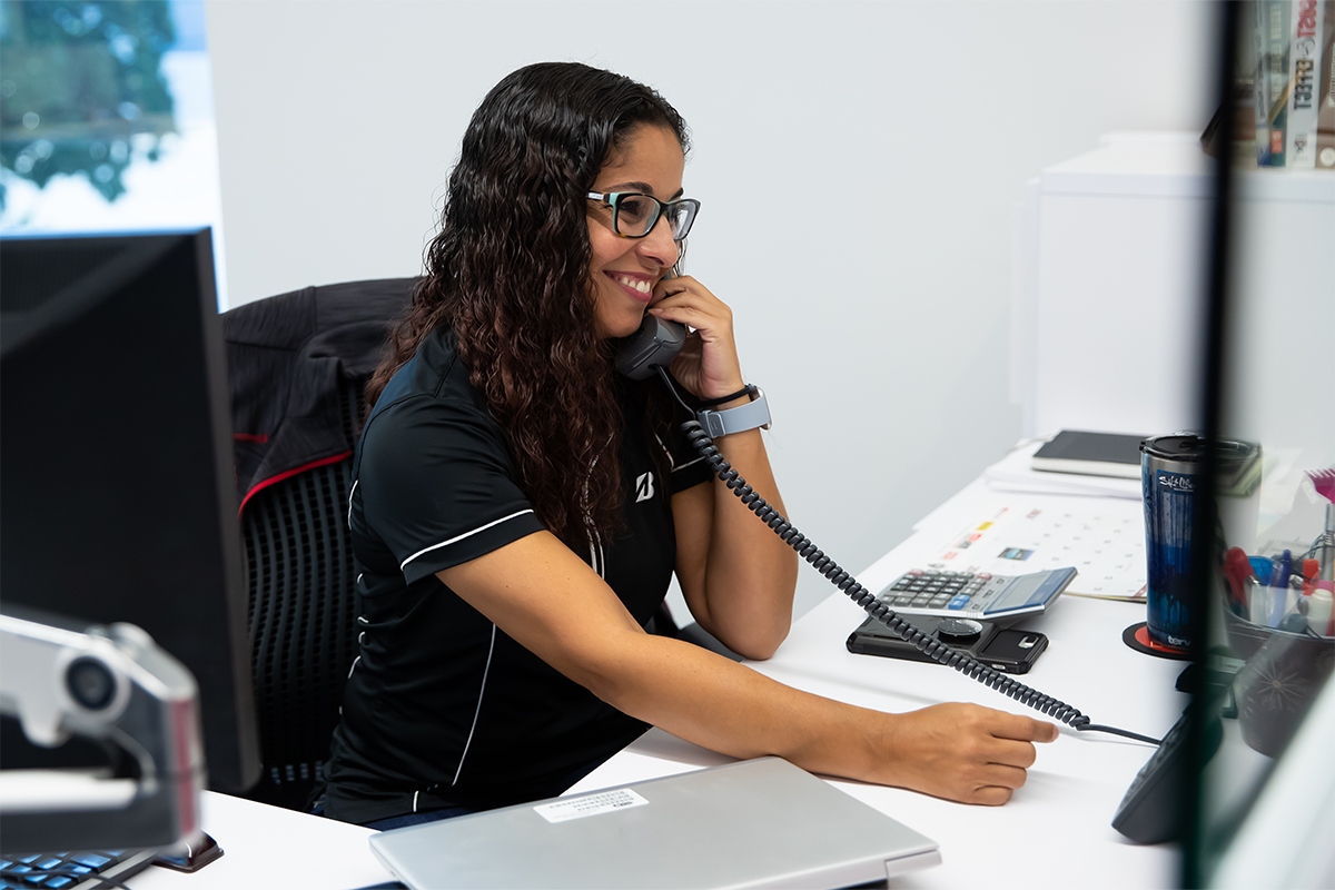 a woman sitting at a desk talking on a phone