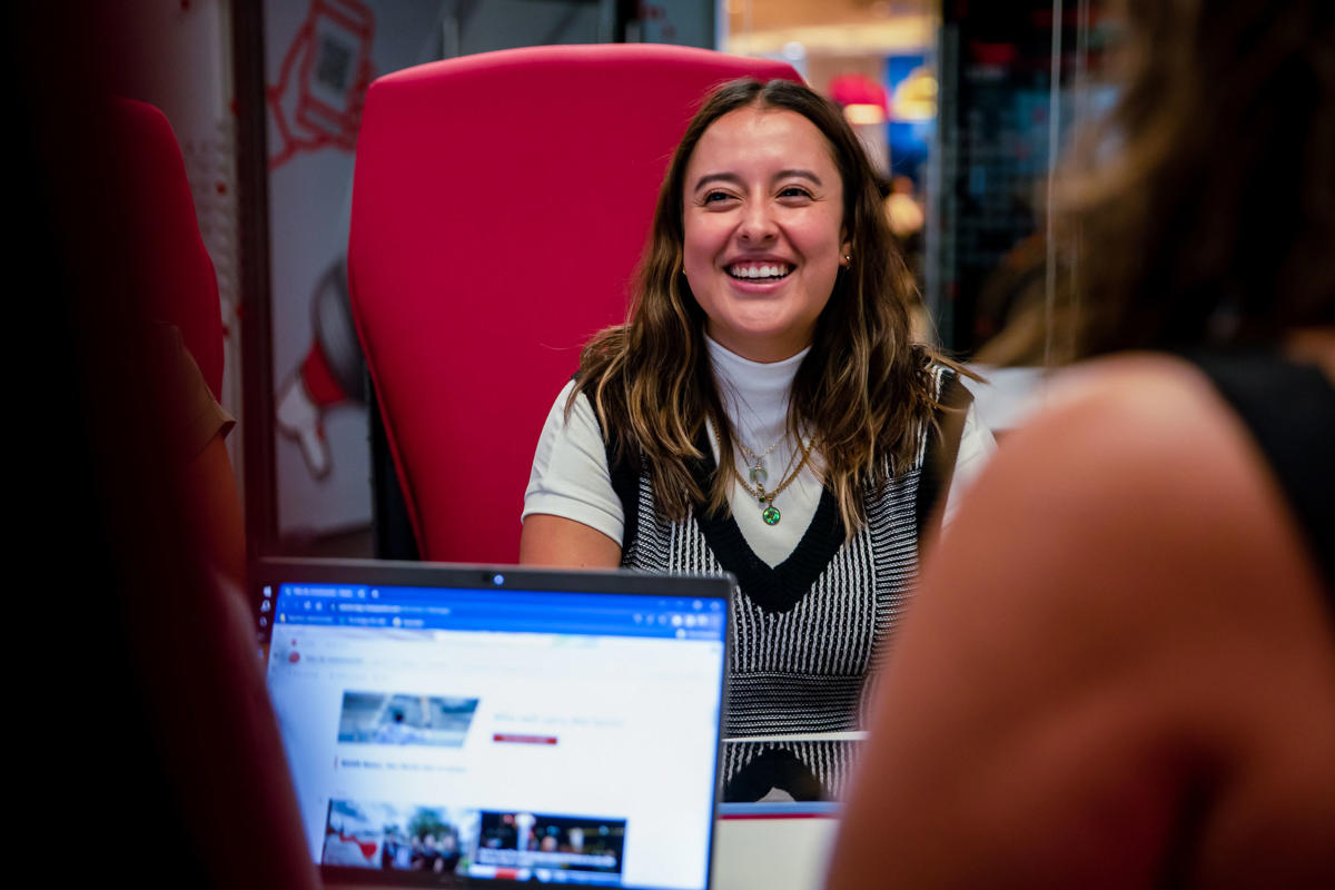 a woman sitting in a red chair smiling