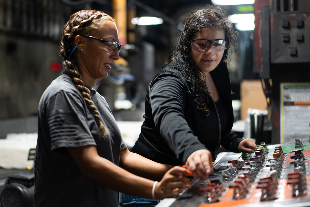 a couple of women working on a machine