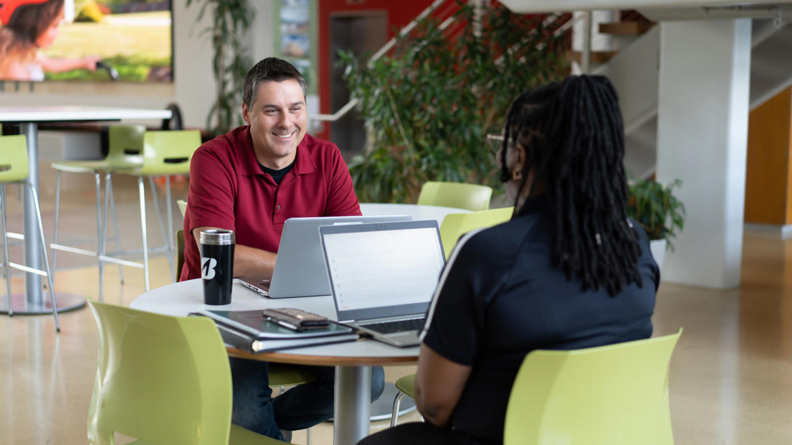 a man and woman sitting at a table with laptops