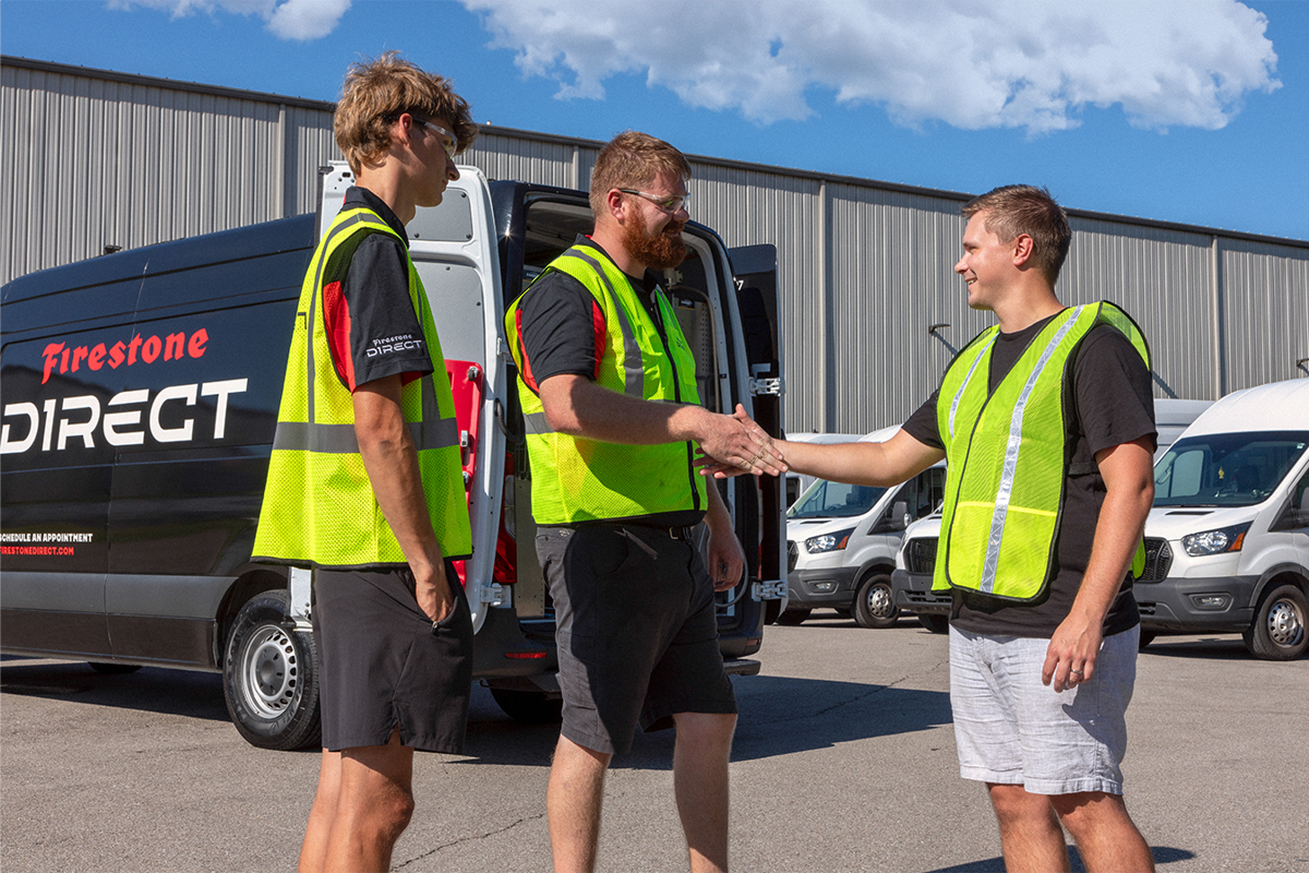 a group of men in reflective vests shaking hands