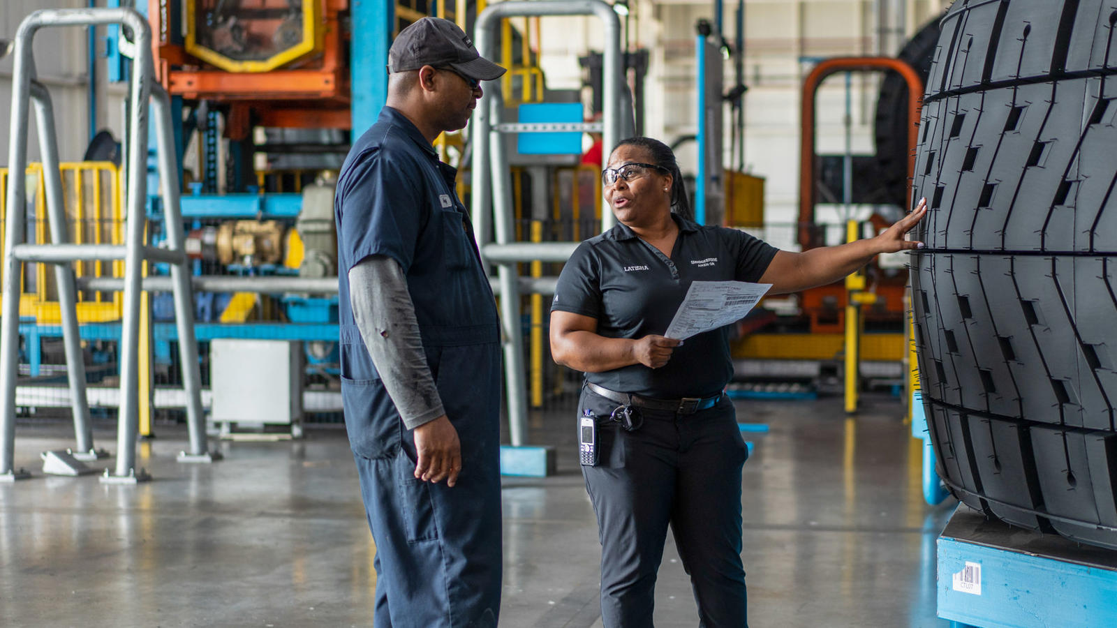 a man and woman standing in a factory