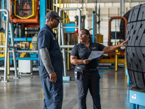 a man and woman standing in a factory