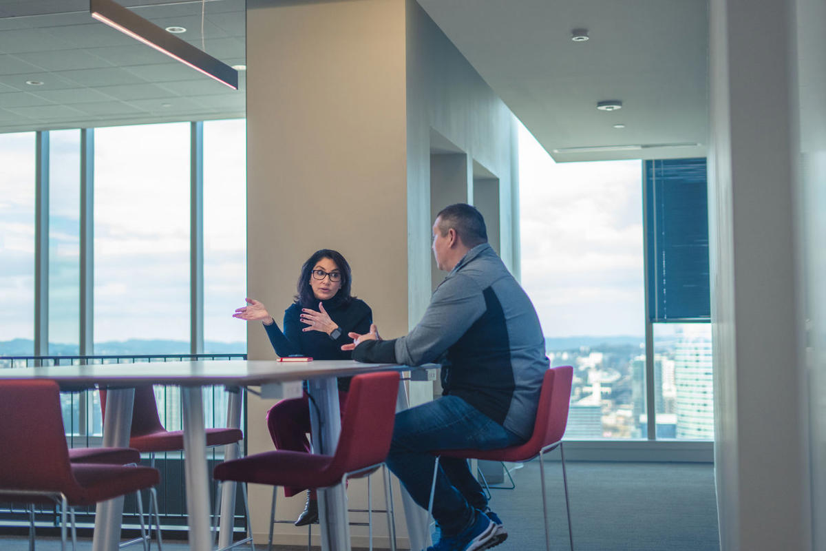 a man and woman sitting at a table talking