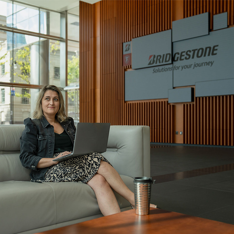 a woman sitting on a couch with a laptop