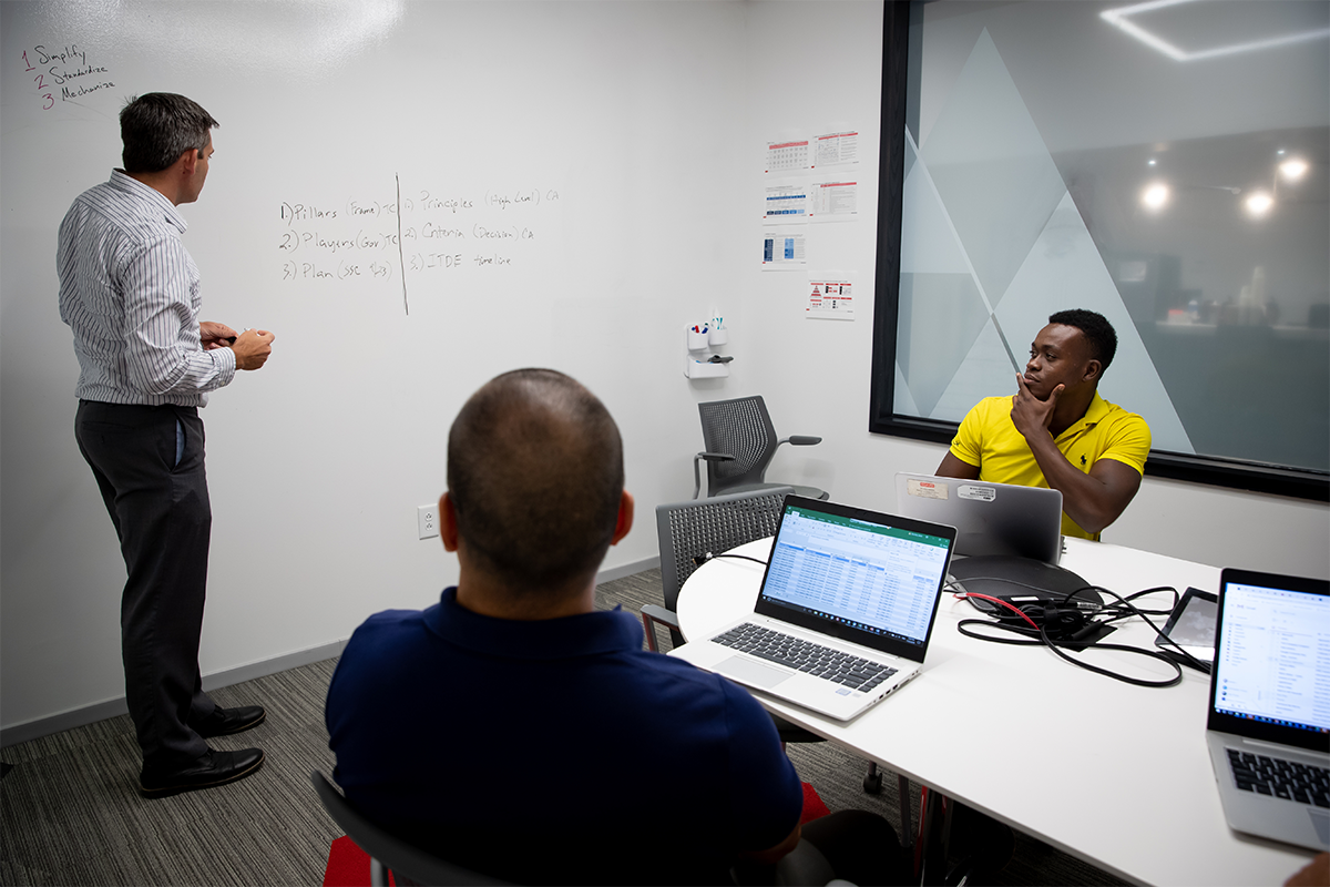 a man standing in front of a whiteboard with a man in front of him