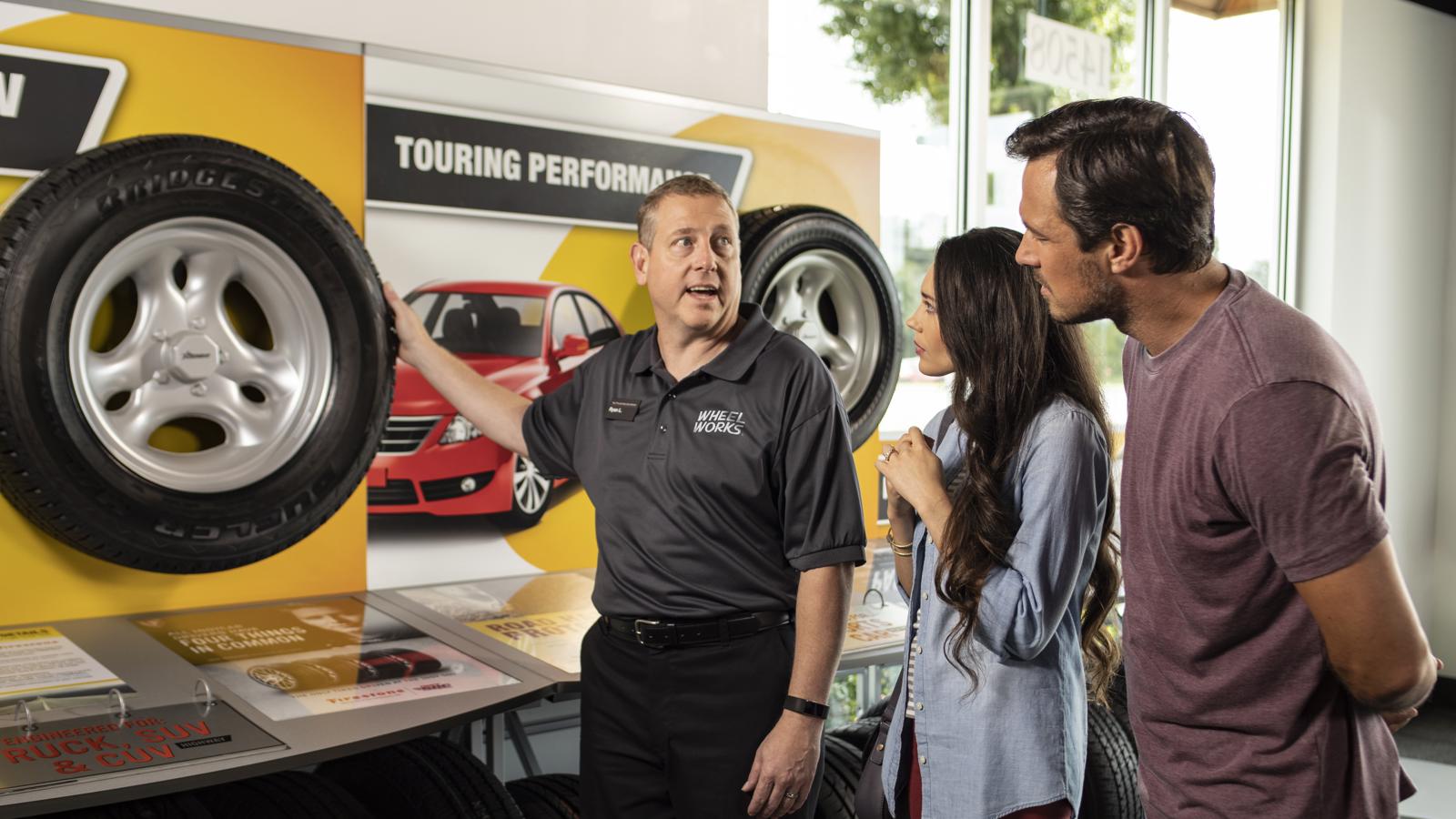 a man showing a couple of people tires