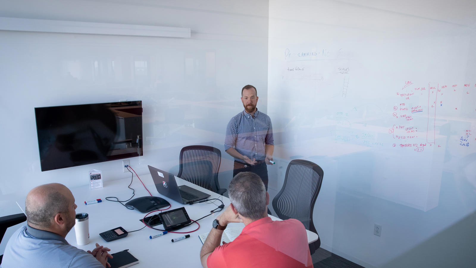 a man standing in front of a whiteboard