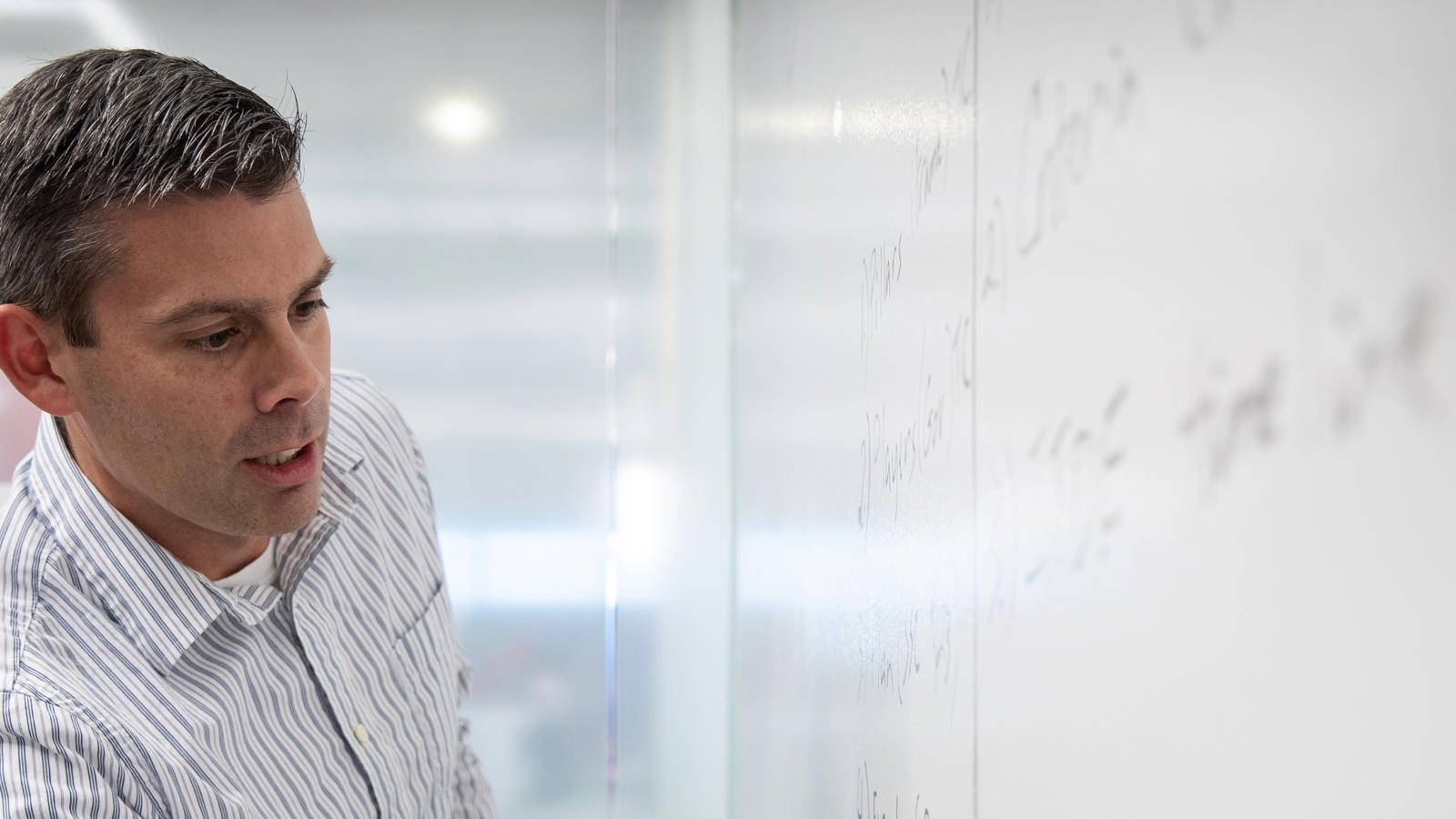 a man looking at a whiteboard