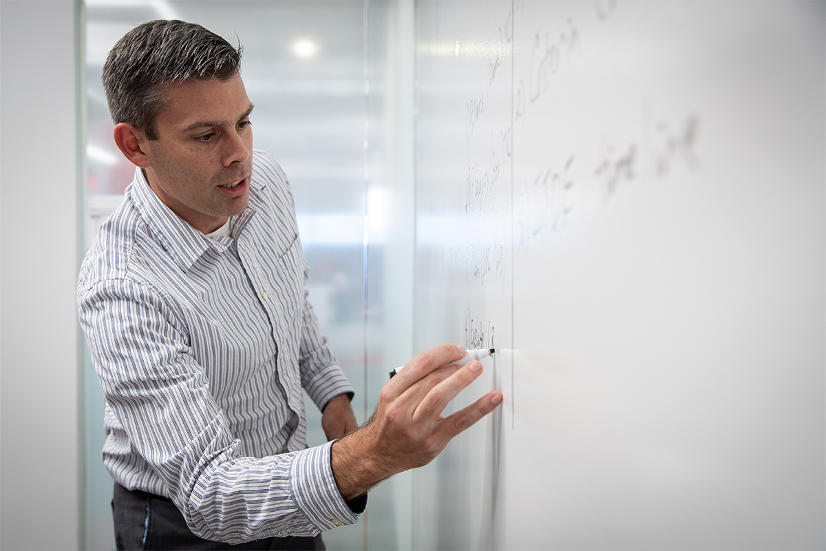 a man writing on a whiteboard