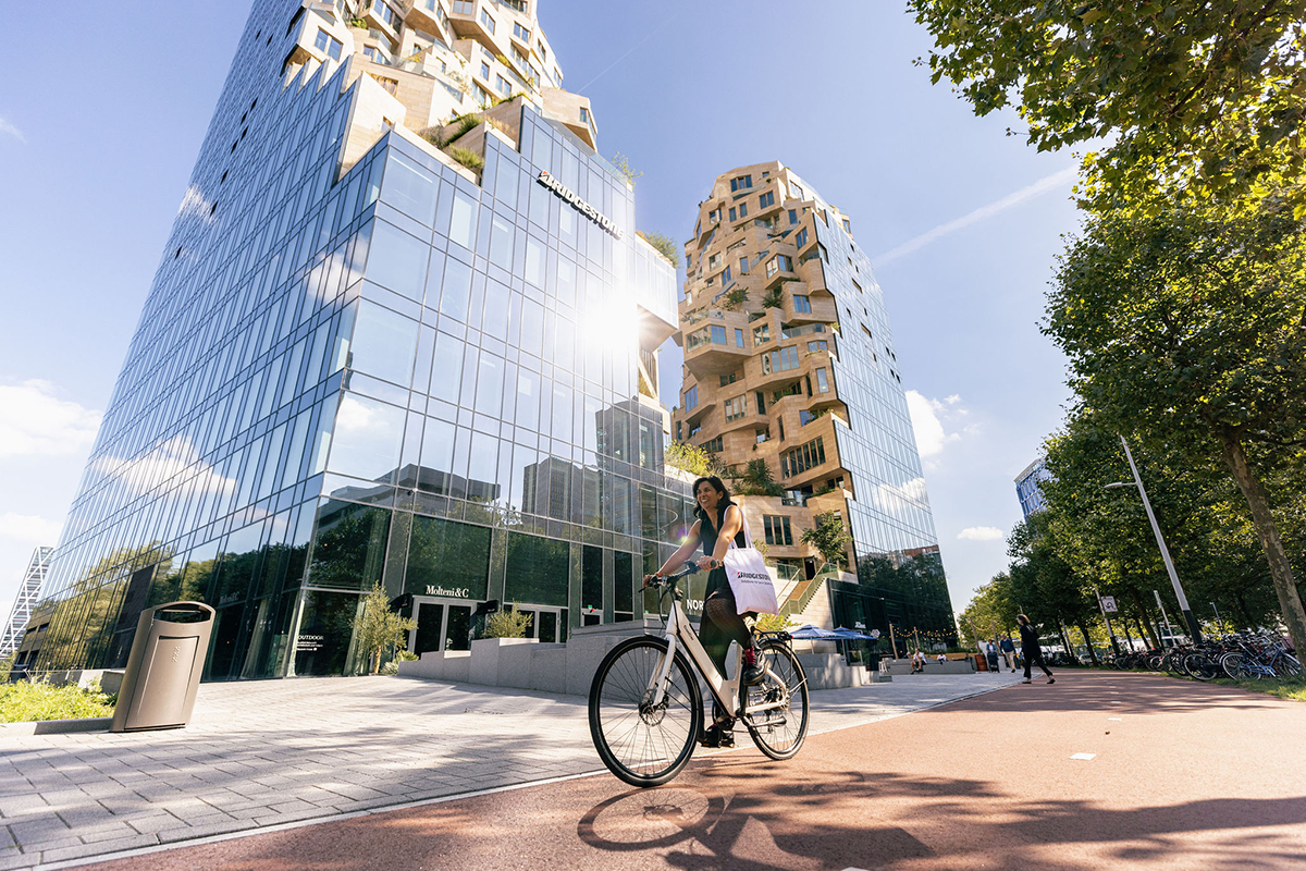 a woman riding a bicycle in front of a tall building