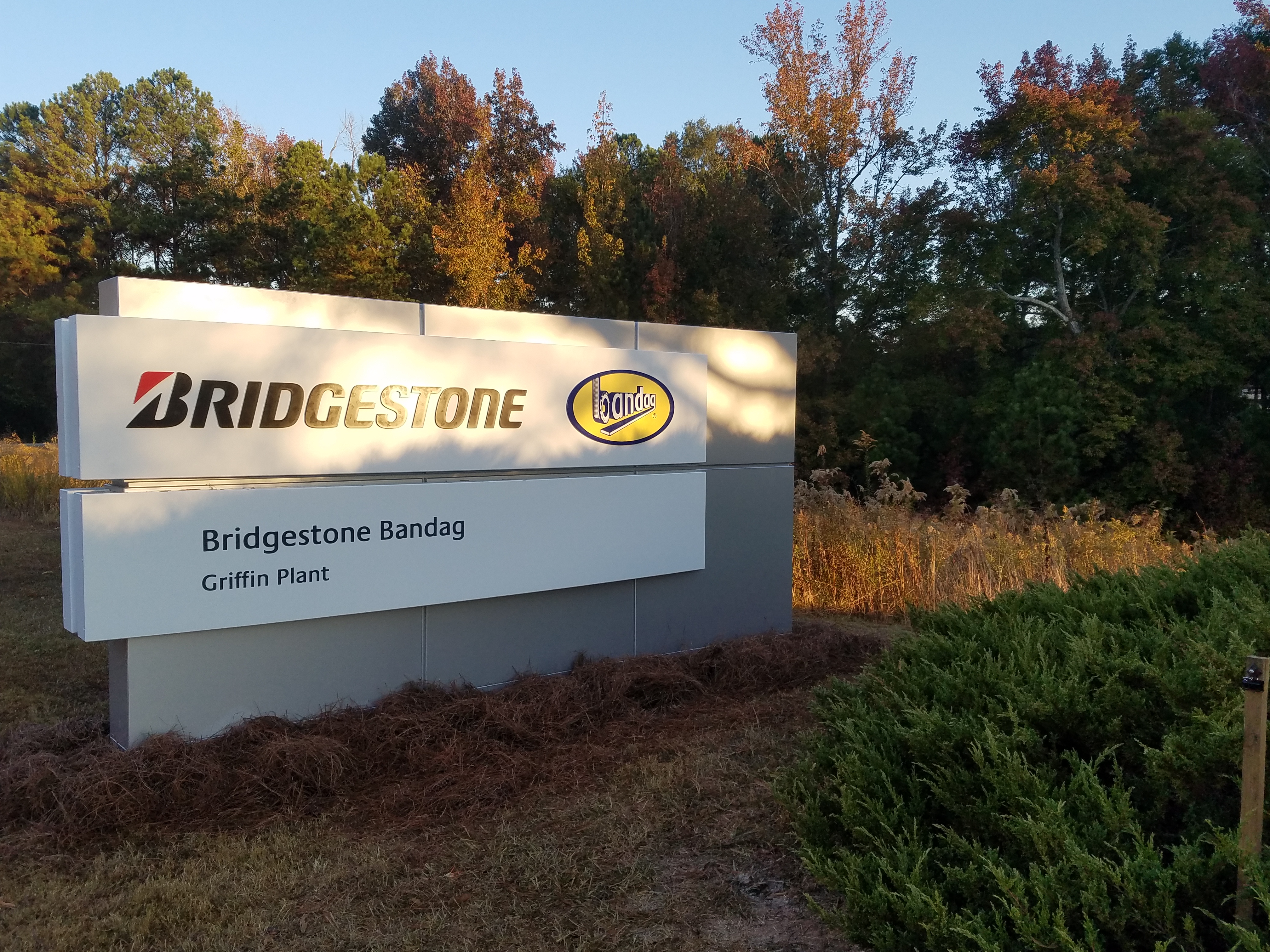 a sign with trees in the background