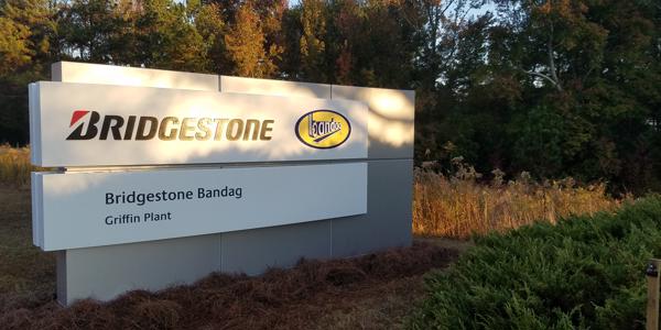 a sign with trees in the background