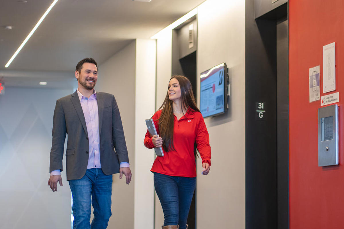 a man and woman walking in a hallway