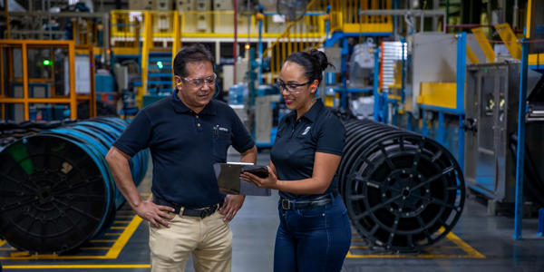 a man and woman standing in a factory