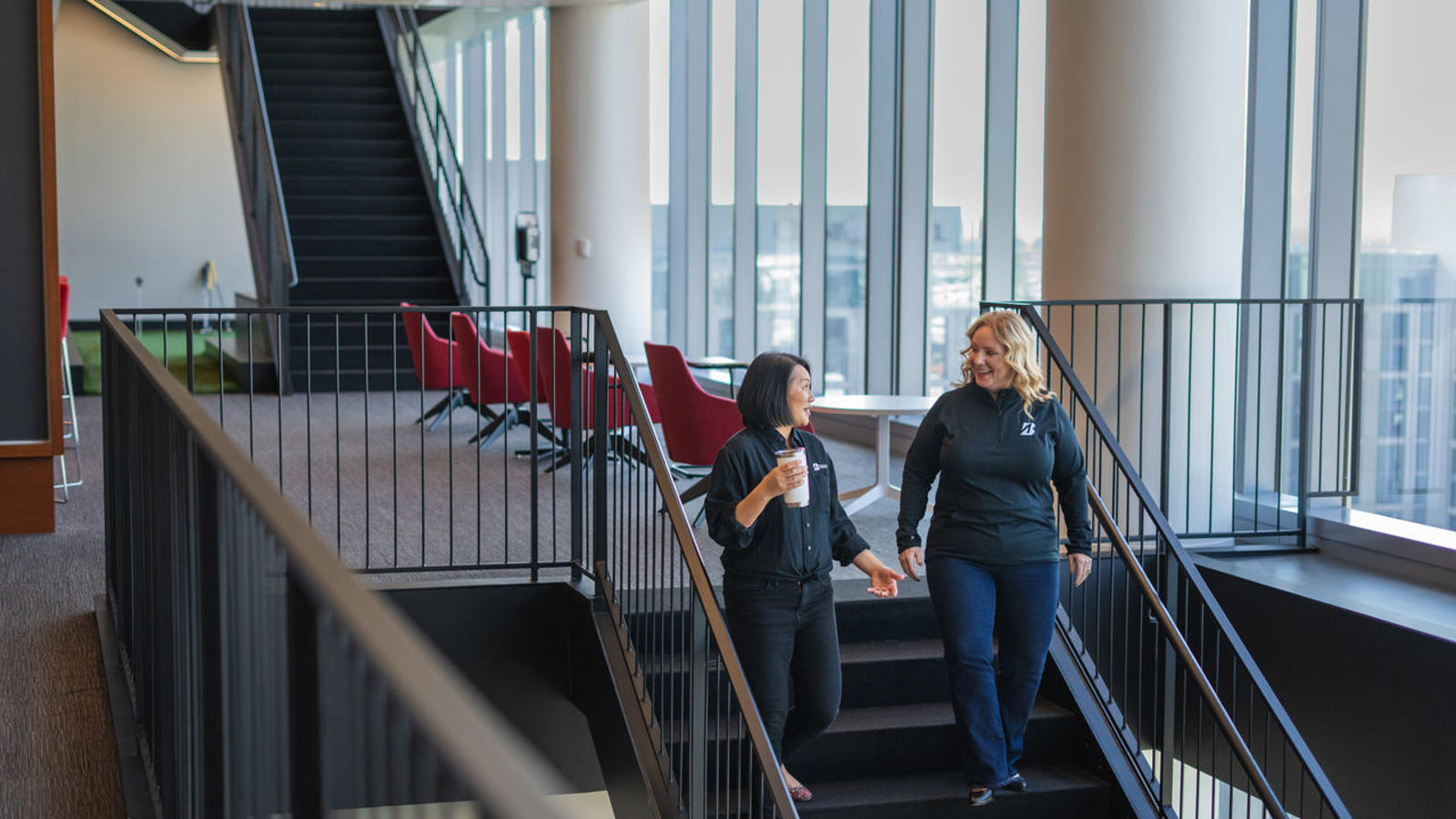 two women walking up stairs in a building